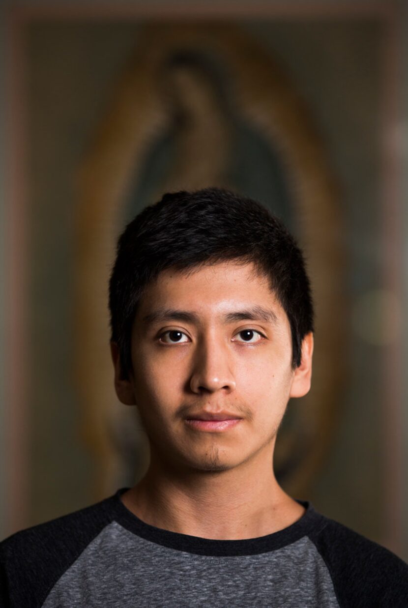 DACA recipient Luis Flores poses for a portrait in front of a painting of the Virgin of...