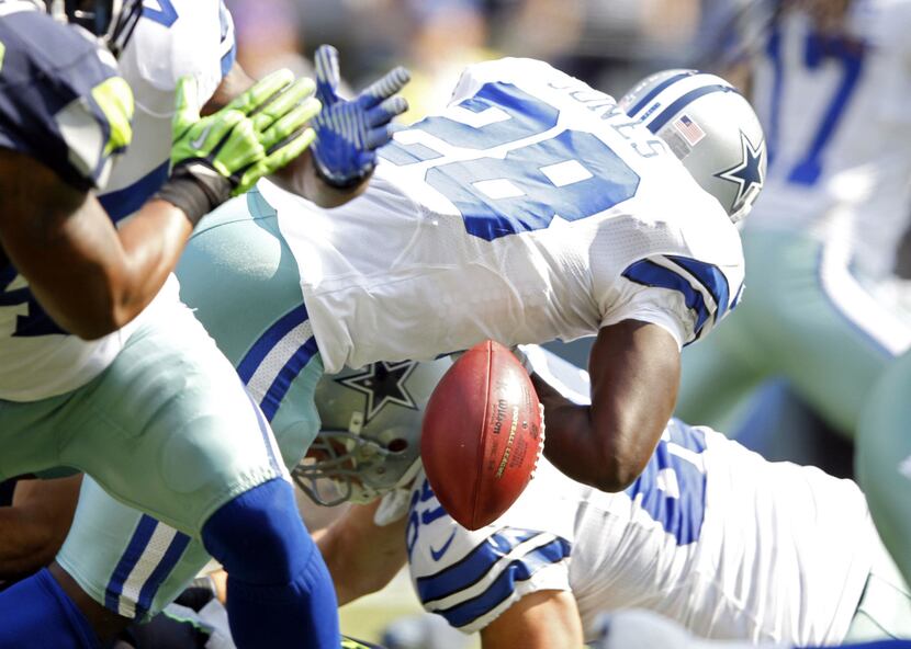 Dallas Cowboys running back Felix Jones (28) fumbles the ball during the first half of play...