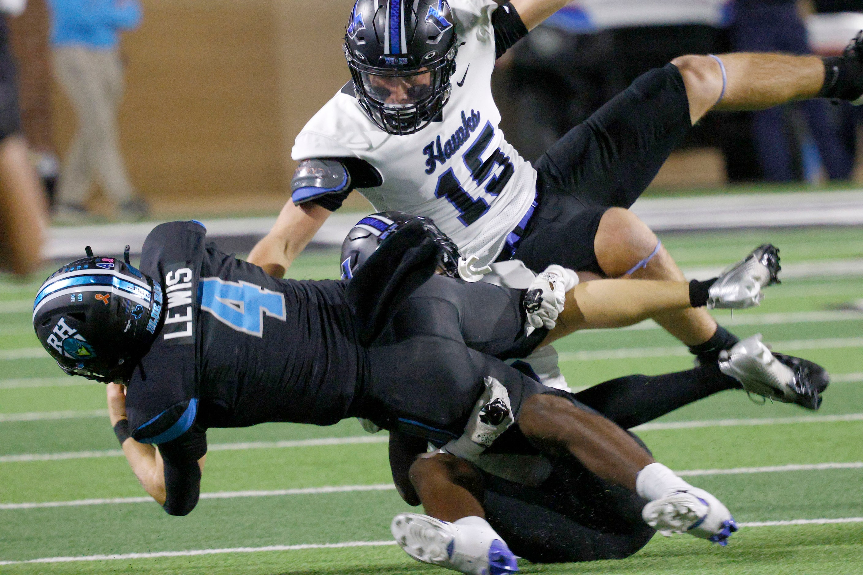 Rock Hill's quarterback Christian Lewis (4) is tackled by Hebron's Eli Mitchell (15) and...