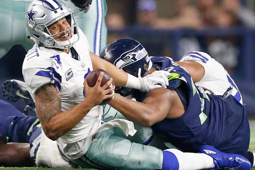Dallas Cowboys quarterback Dak Prescott (4) is tackled by Seattle Seahawks defensive end...