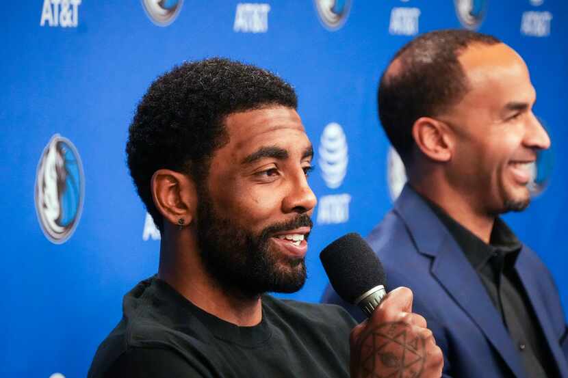 Dallas Mavericks guard Kyrie Irving (left) answers a question during press conference with...