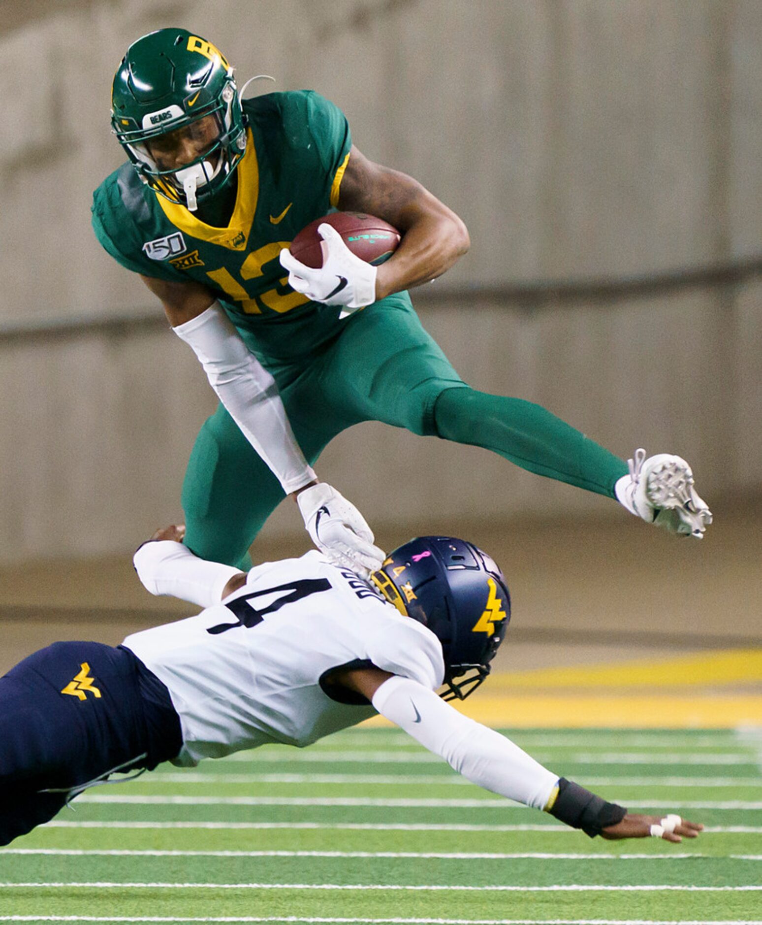 Baylor wide receiver R.J. Sneed (13) hurdles West Virginia safety Josh Norwood (4) during...