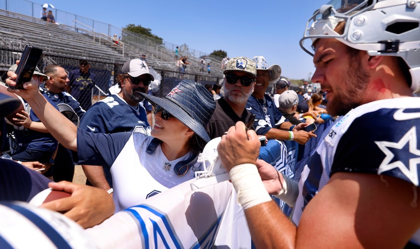 Fan Sherri Montano of Bakersfield, California (left) takes a photo of Dallas Cowboys running...