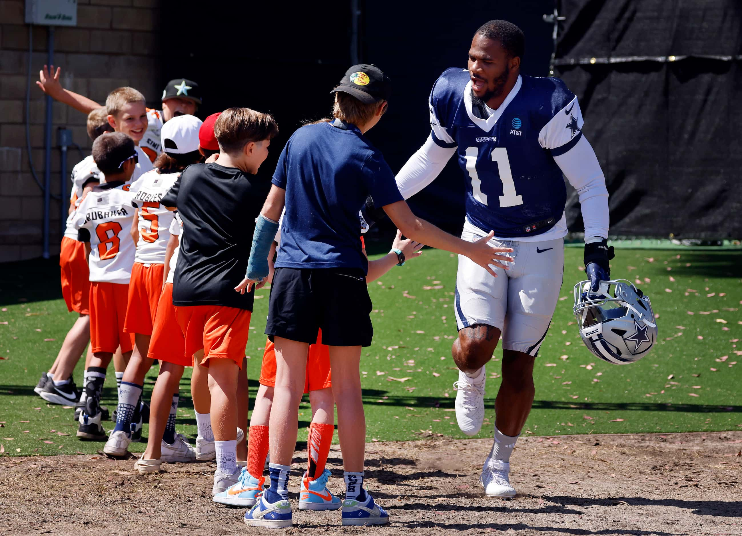 Dallas Cowboys linebacker Micah Parsons (11) slaps hands with Simi Valley Bulldogs youth...