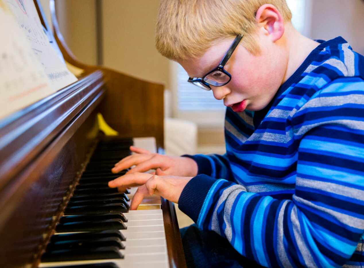 Ben Schneider, 11, plays Ben Folds' "Sky High" on piano in his home on Tuesday, April 12,...