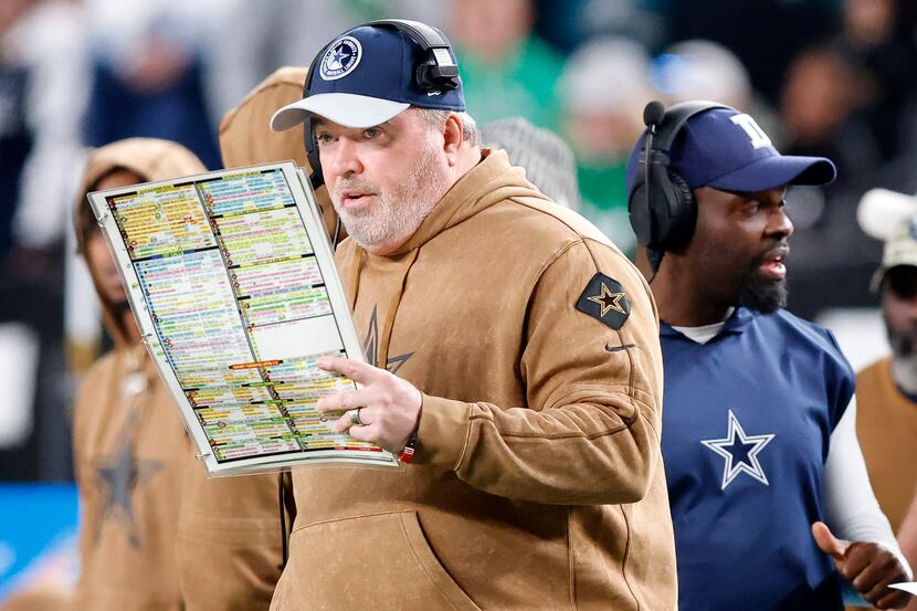 Dallas Cowboys head coach Mike McCarthy calls a play from his sheet during the second half...