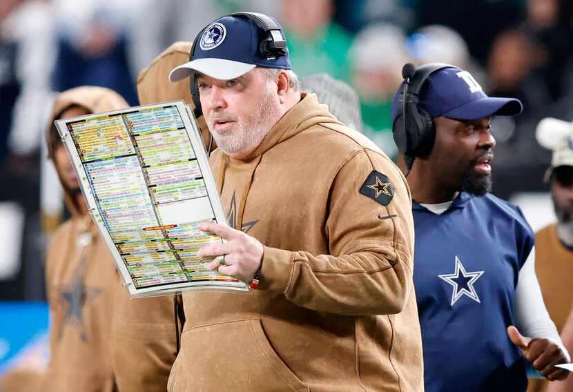 Dallas Cowboys head coach Mike McCarthy calls a play from his sheet during the second half...