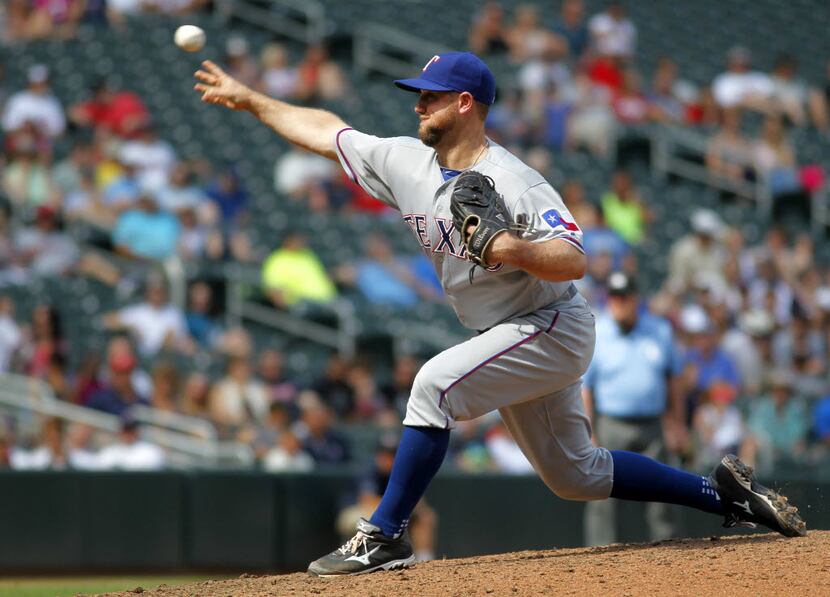Texas Rangers catcher Bryan Holaday pitches in the eighth inning against the Minnesota Twins...