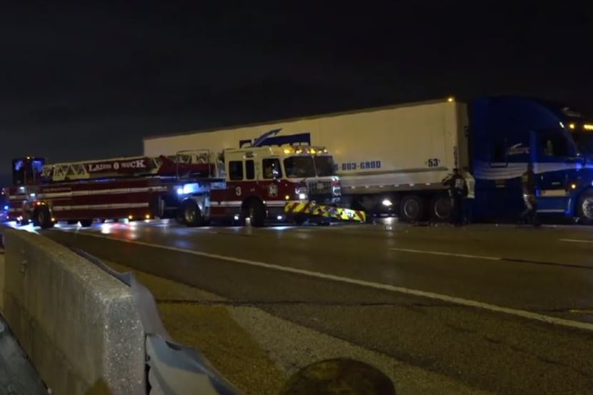 A Dallas fire truck sits alongside an 18-wheeler after an accident on Interstate 30 in Far...