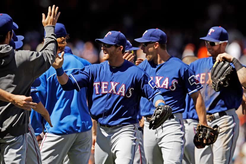 The Texas Rangers celebrate a 5-0 win over the San Francisco Giants during a baseball game...