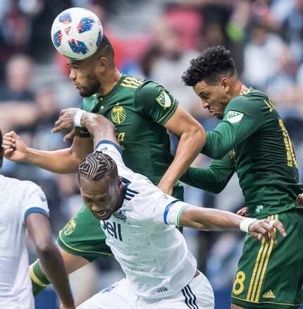 Portland Timbers' Bill Tuiloma, back left, gets his head on the ball in front of teammate...
