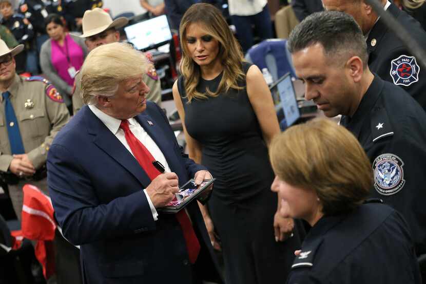 President Donald Trump signs autographs for first responders of Saturday's mass shooting ...