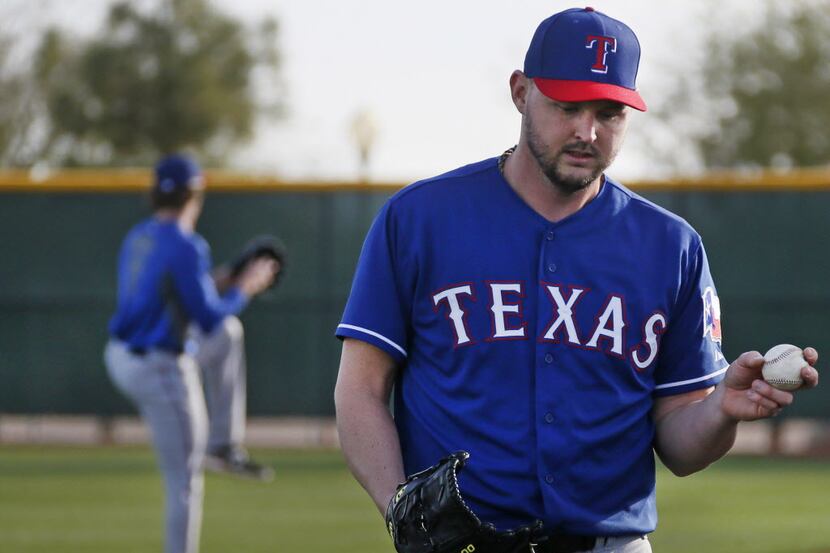 Texas pitcher Matt Harrison arrives for his first throwing session of the spring as pitchers...