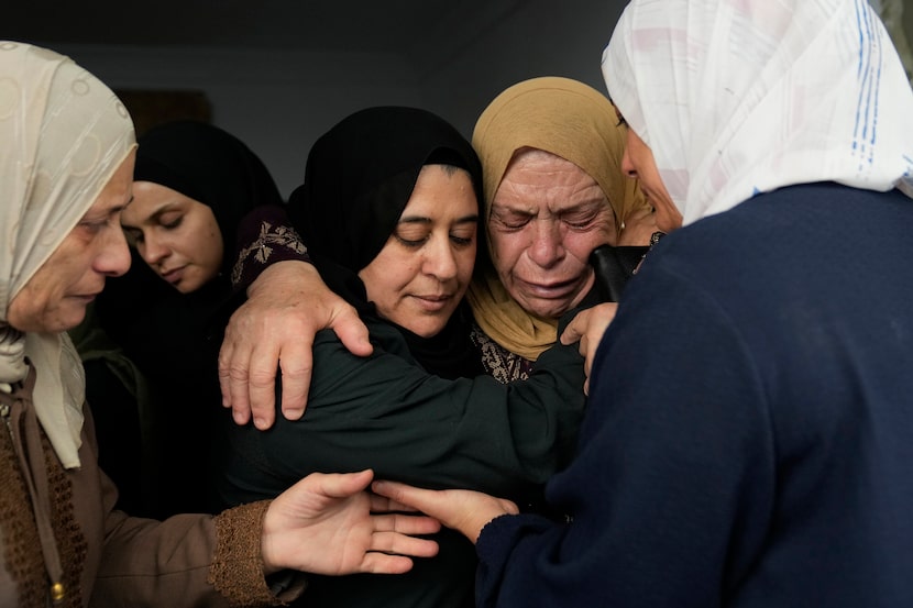 Mourners cry during the funeral of 18 Palestinians who were killed in an Israeli in...