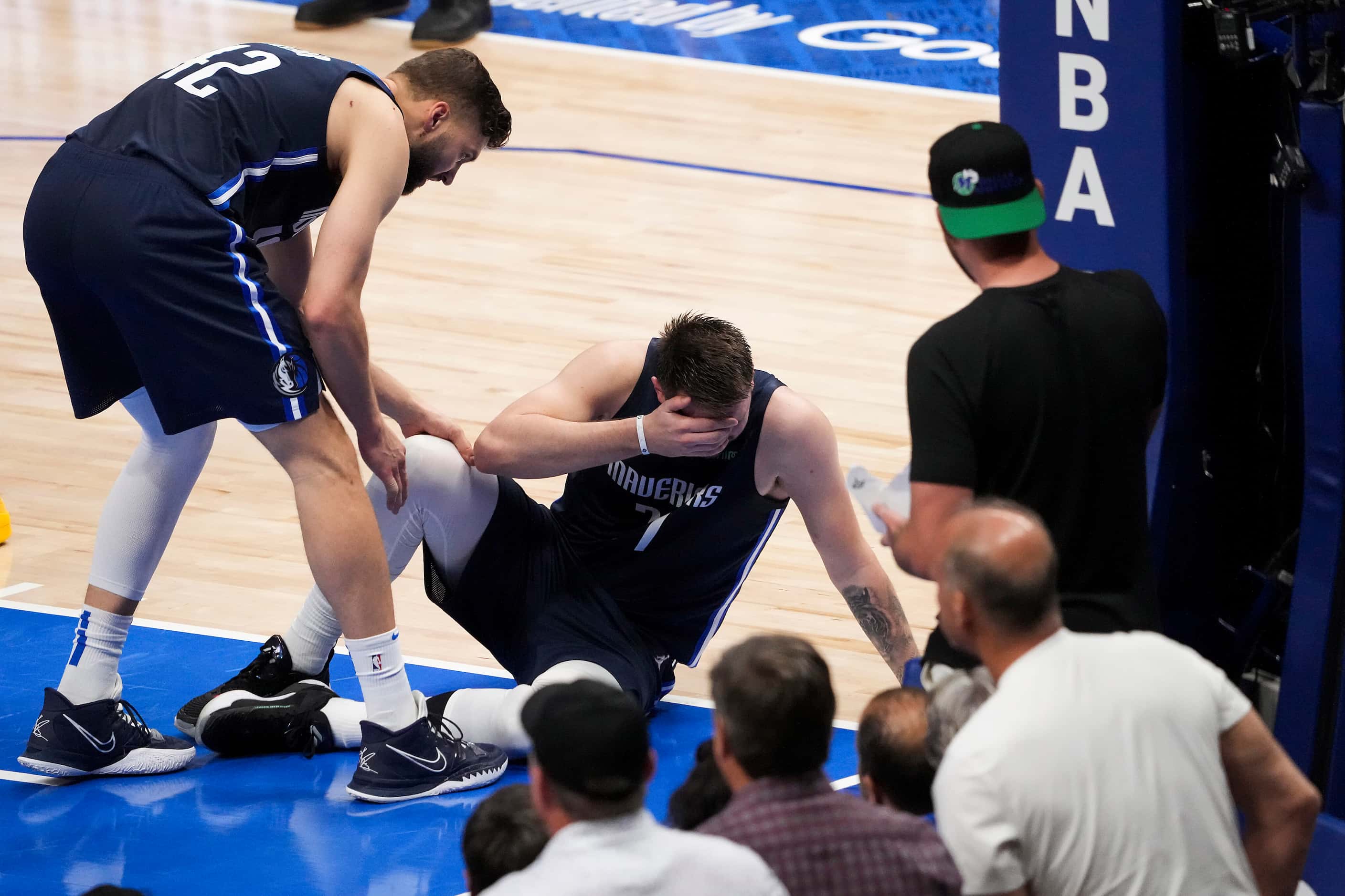 Dallas Mavericks guard Luka Doncic (77) collapses to the fool after bing called for a foul...