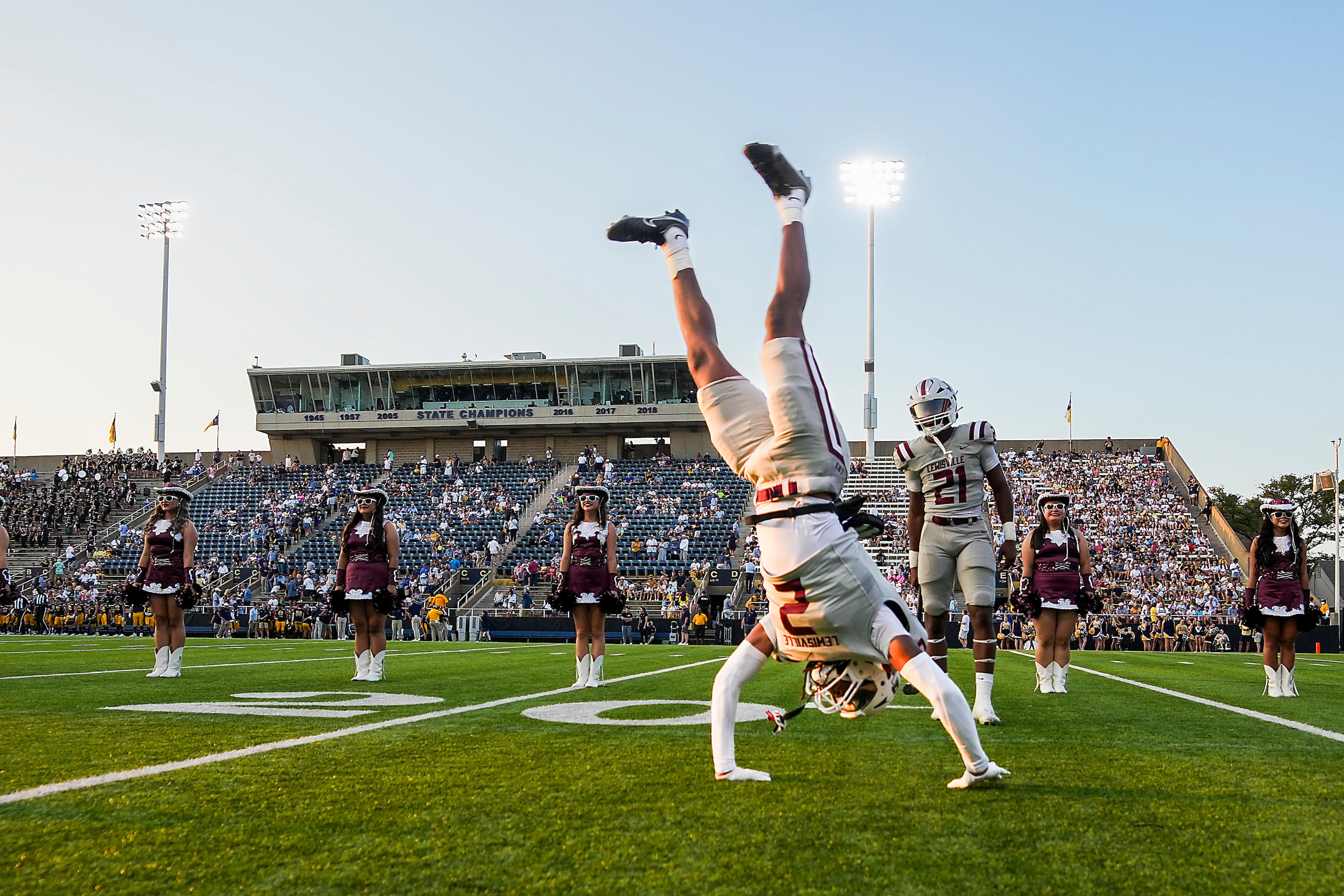 Lewisville’s Zephen Walker (2) does a cartwheel as he takes the field before a high school...