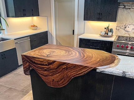 Custom wood countertop that seems to spill over the edge of the island