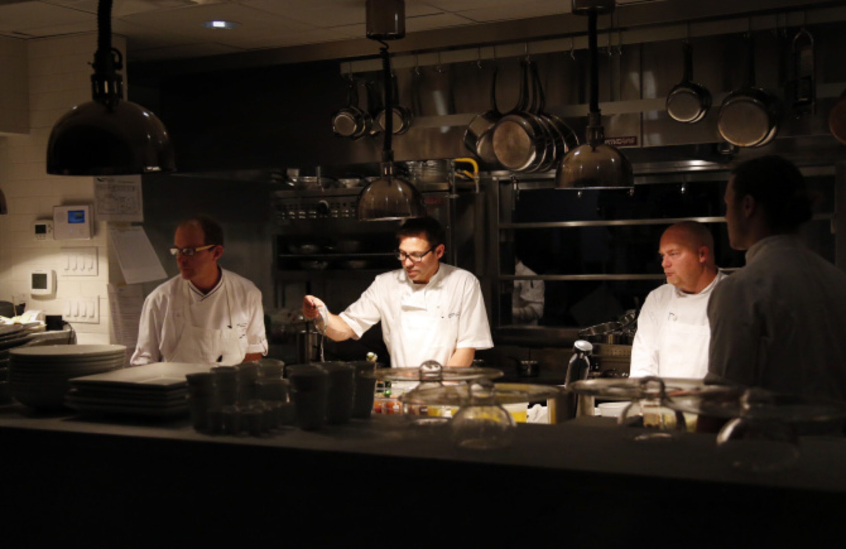 SPOON: Chef John Tesar, center, with his kitchen crew, works in the open kitchen.