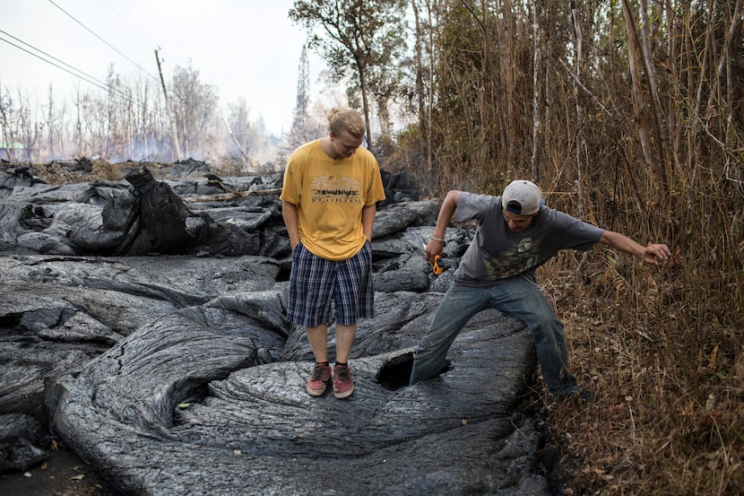 Brandon Lofgreen, left, stands beside Thomas Robinson as he kicks a hole through recently...