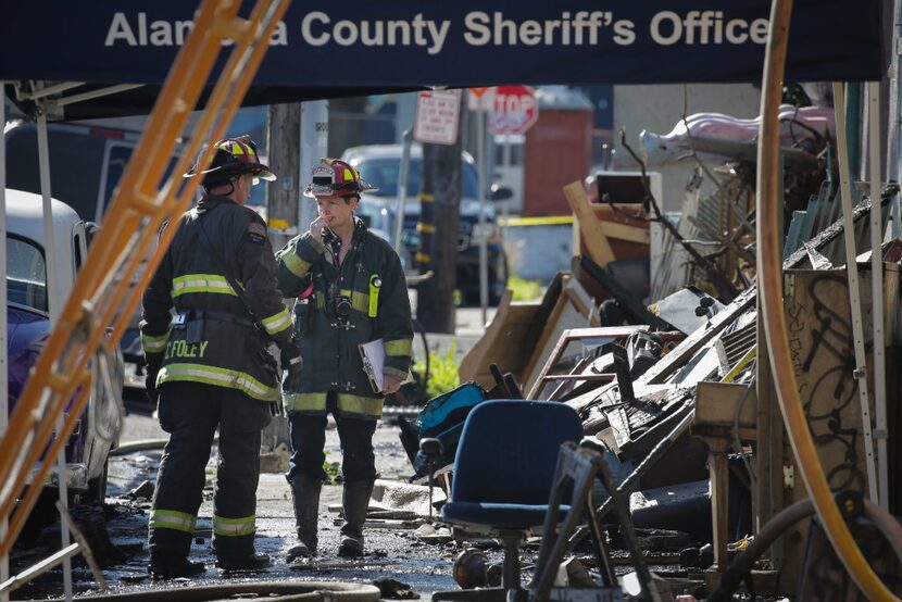 Firefighters work on the scene following an overnight fire that claimed the lives of at...