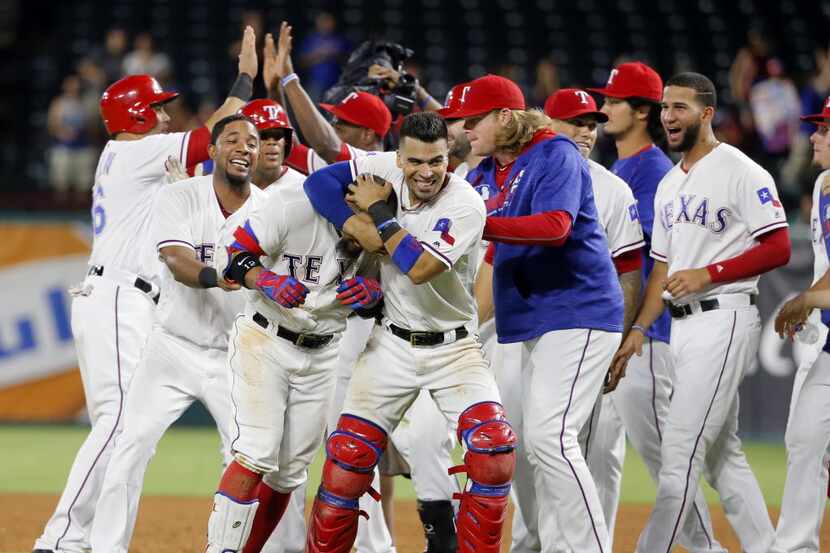 Texas Rangers catcher Robinson Chirinos grabs Rougned Odor in a headlock as Elvis Andrus,...