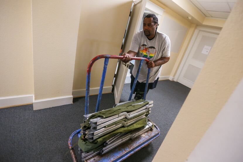 Louis Wright, of Dallas, pushes a dolly full of cots at Oak Lawn United Methodist Church in...