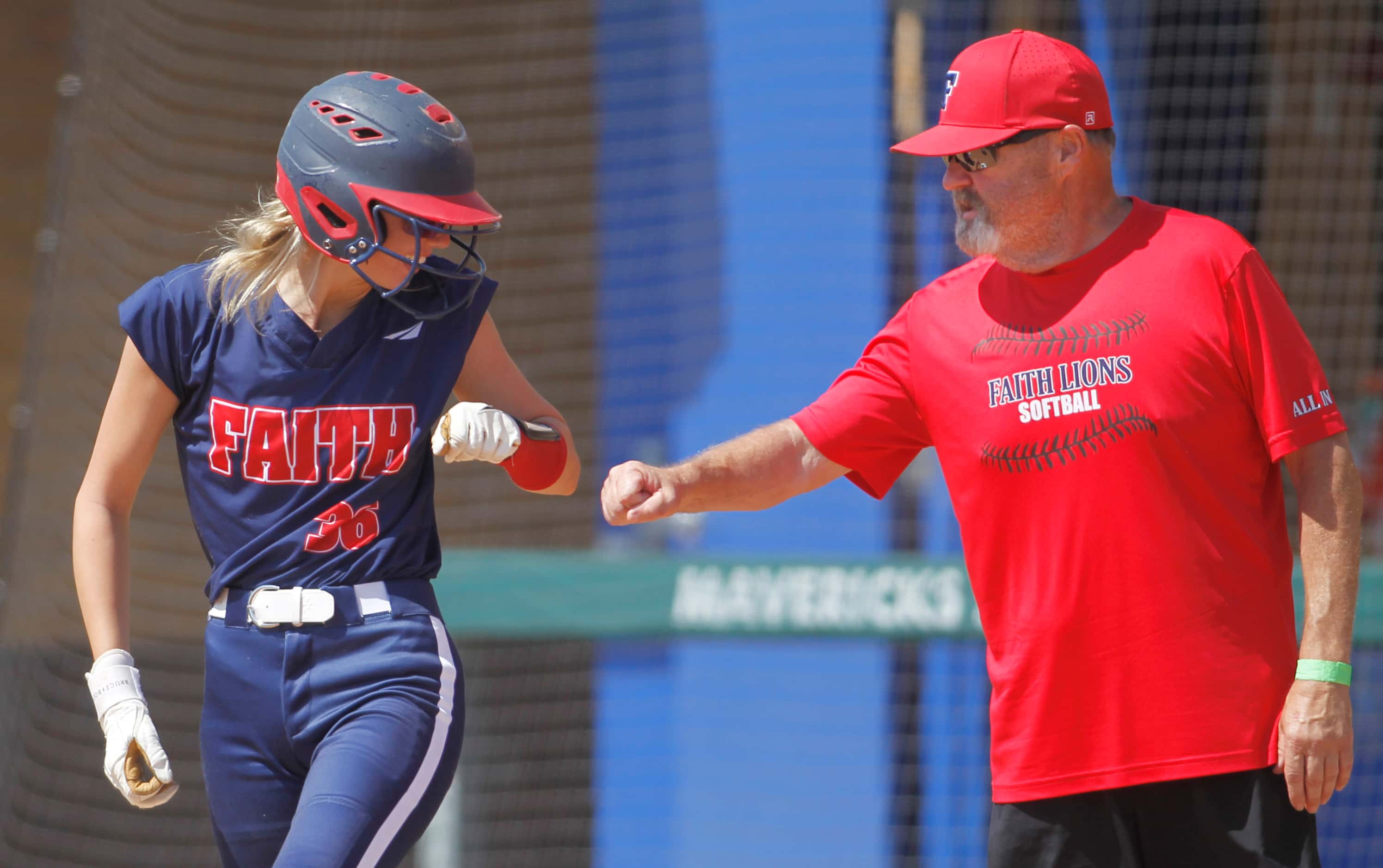 Grapevine Faith Christian pitcher Makenzie Byler (36) shares a fist bump with assistant...