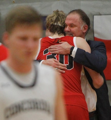 Plano John Paul ll head coach Dan Lee shares a hug with forward Liam McNeeley (30) during...