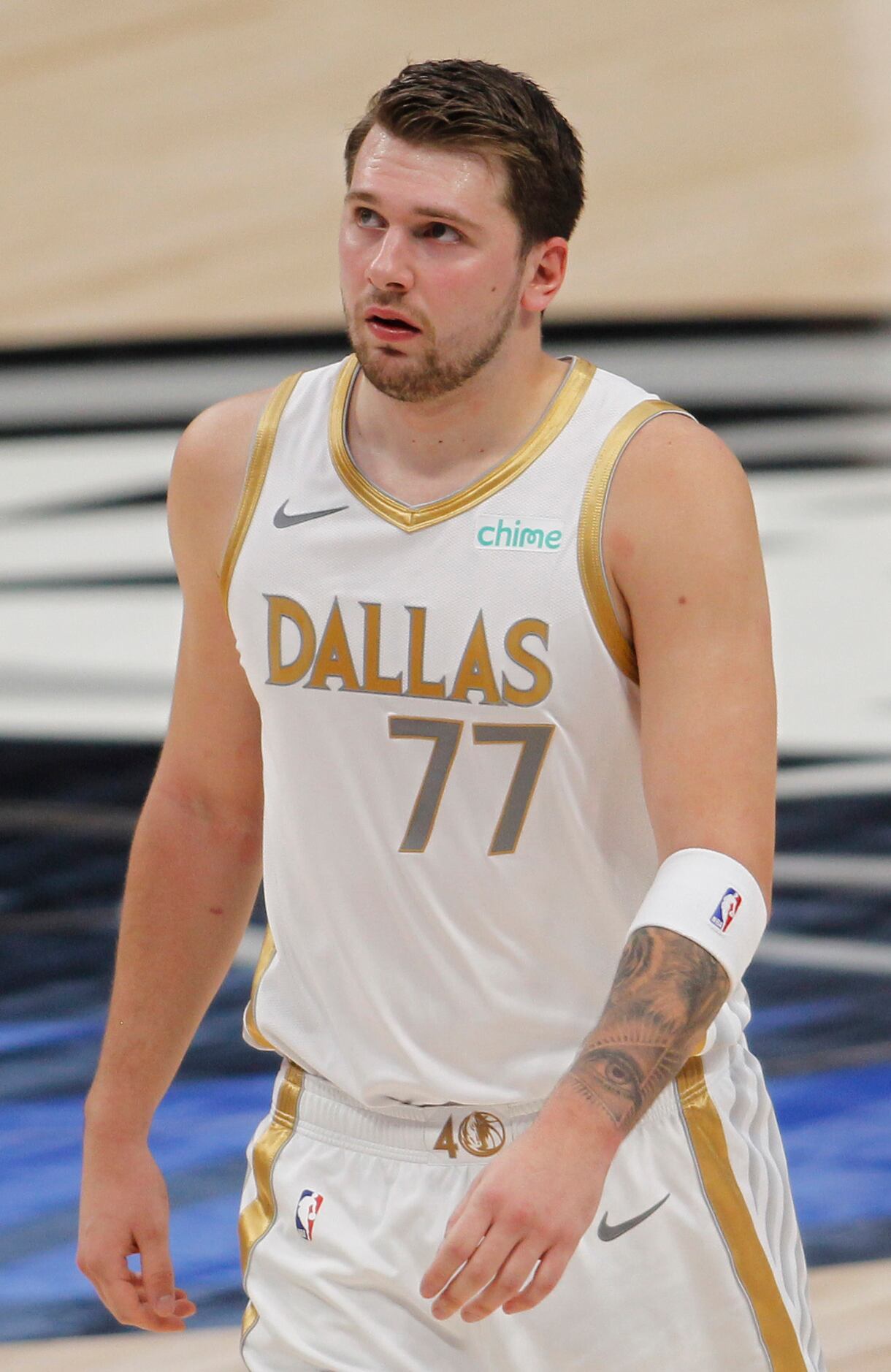 Dallas Mavericks point guard Luka Doncic (77) glances up to the overhead scoreboard as he...