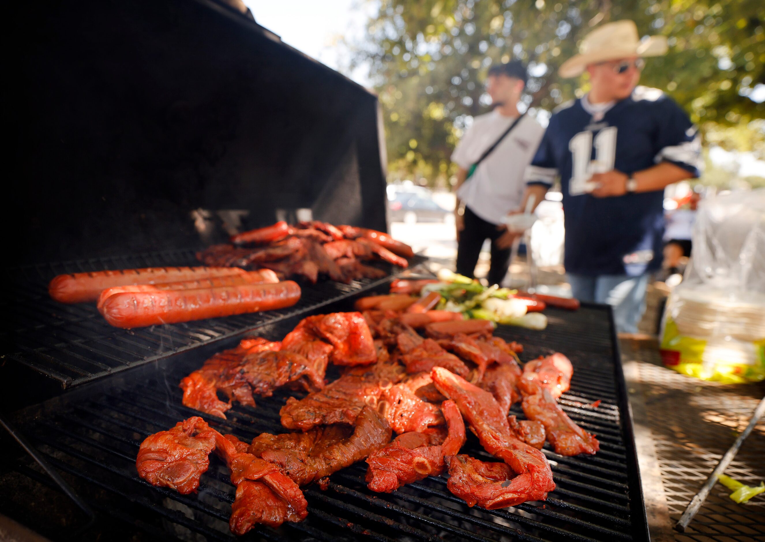 Dallas Cowboys fans grills tablitas, sausages and ribs during a tailgate before the home...