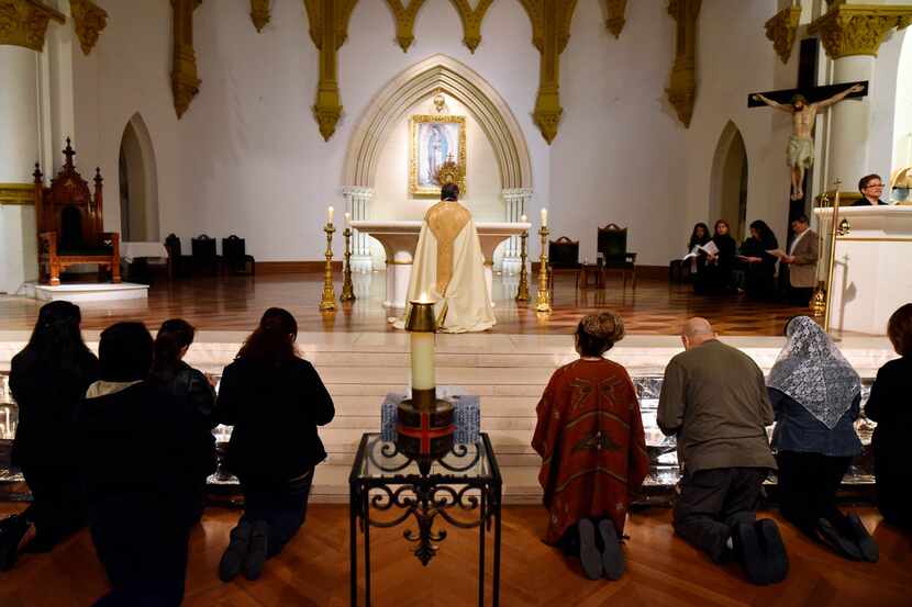 Priest Ruben Ortiz Montelongo, center, leads a prayer during a vigil for immigrants on...