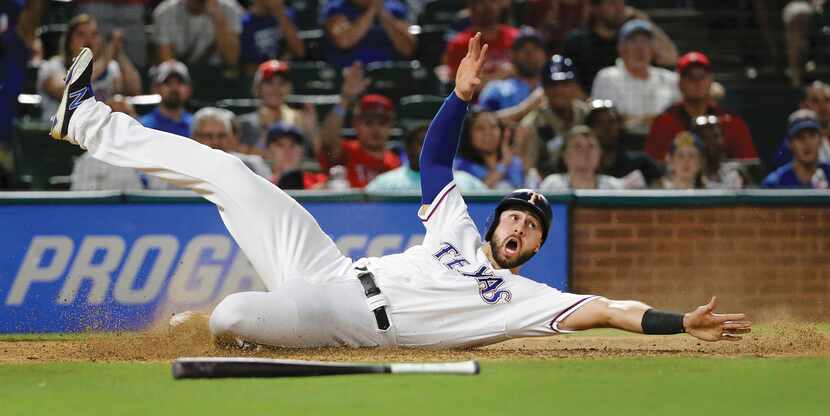 Rangers third baseman Joey Gallo slides into home for a score in the eighth inning of a home...