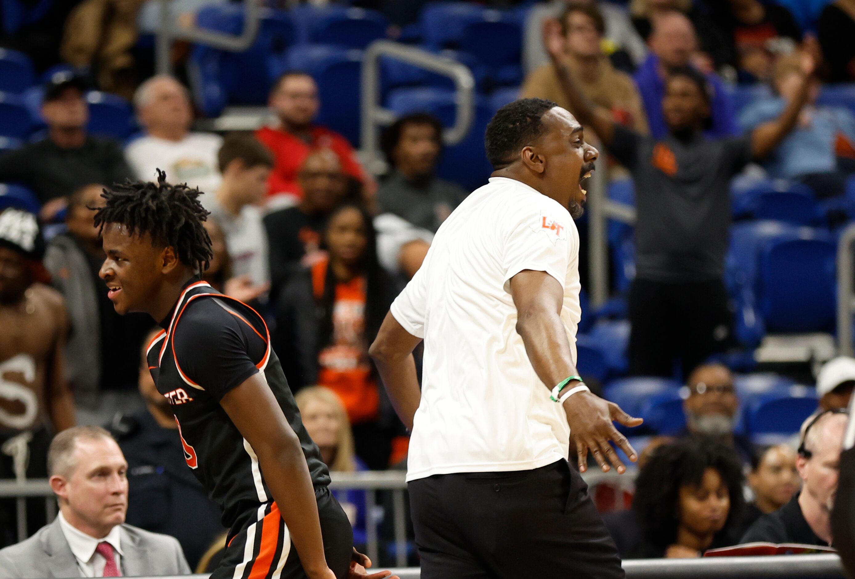 Lancaster head coach Ferrin Douglas runs to celebrate with players after winning the UIL...