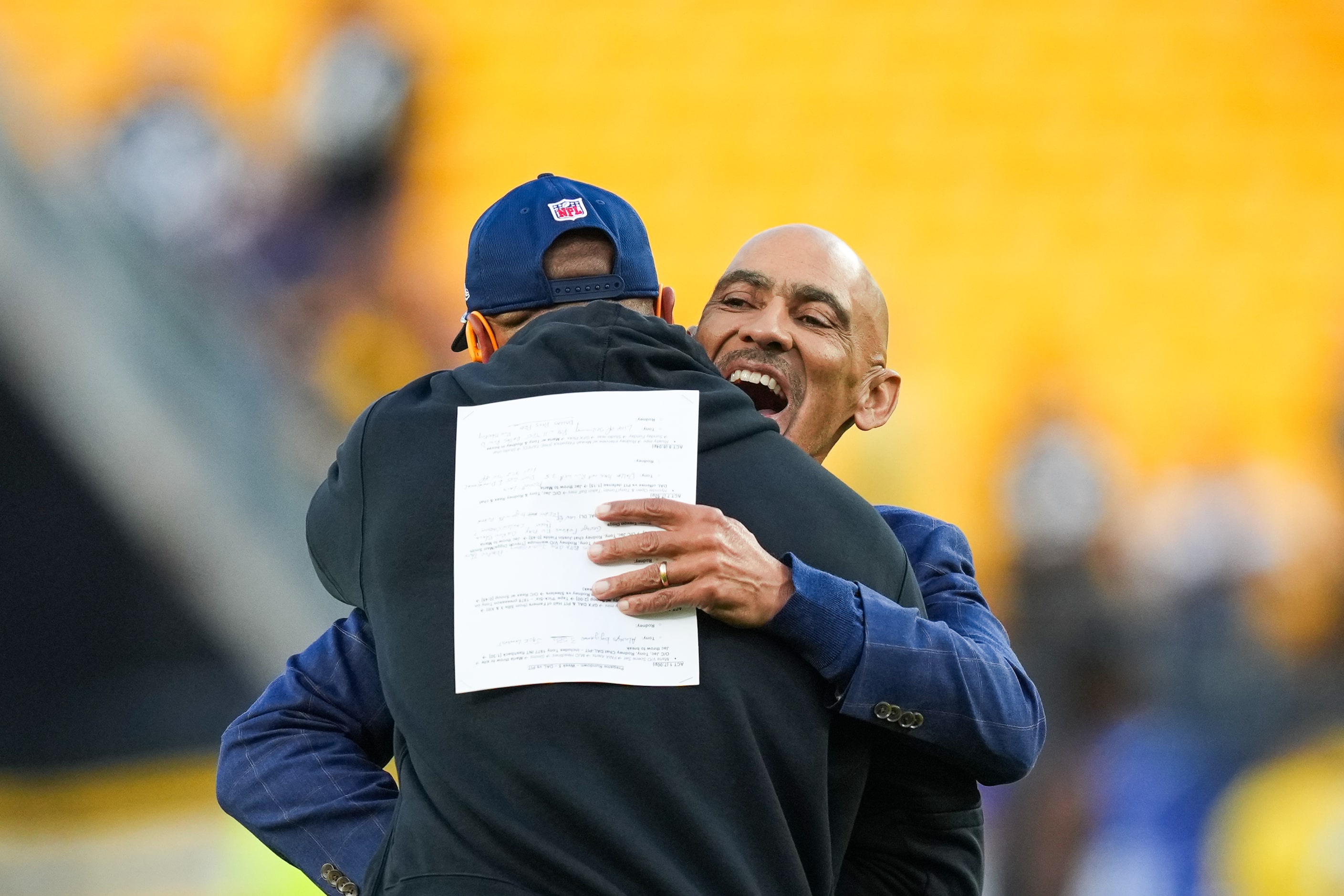 Tony Dungy hugs Dallas Cowboys quarterback Dak Prescott as the teams warm up before an NFL...