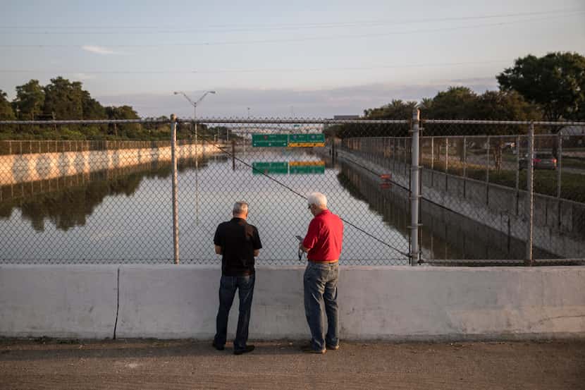Lance Leibole, left, and John Lee take pictures of a portion of the Sam Houston Tollway in...