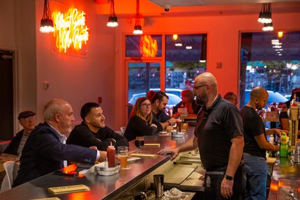 Owner Bryan Kaeser (right) visits with customers during the soft opening of Mudhook in...