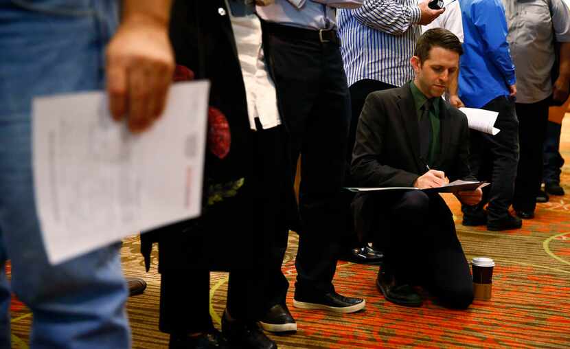 Brady Snowden fills out forms while in line during the You're Hired Job Fest at the Sheraton...