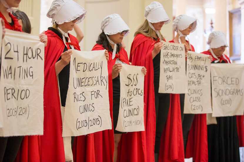 Abortion rights activists dressed as characters from "The Handmaid's Tale" protest the...