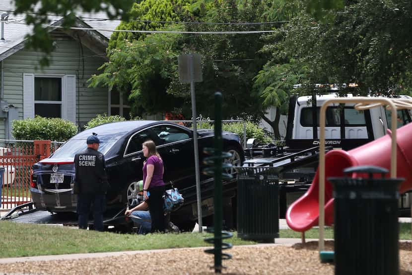 A Cadillac is removed from a crime scene after two people were found dead in the trunk at...