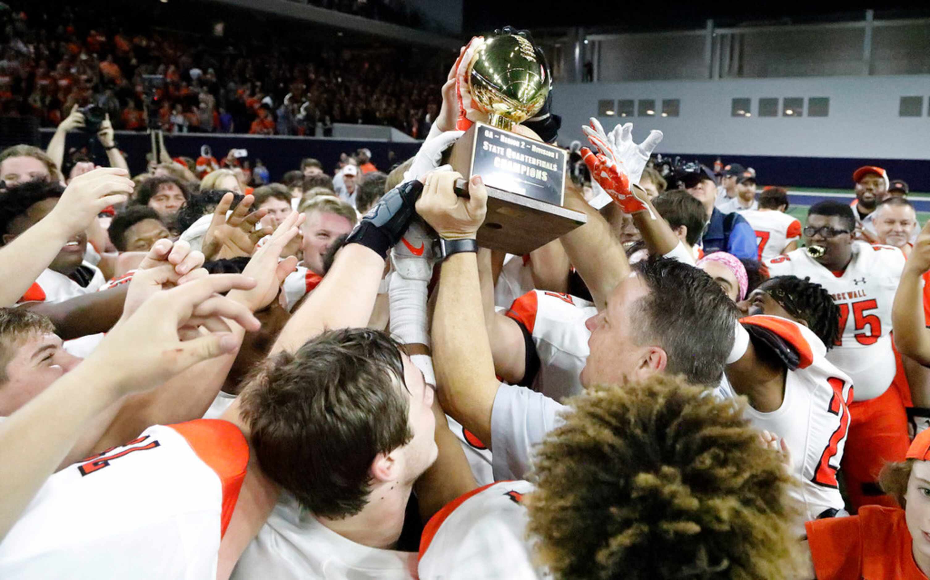 Rockwall High School head coach Rodney Webb hosts up the area champions trophy as his team...