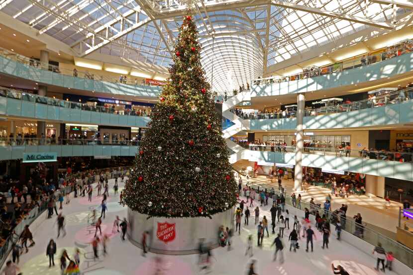 Gente patina en hielo alrededor del gran árbol de Navidad en Galleria Dallas.