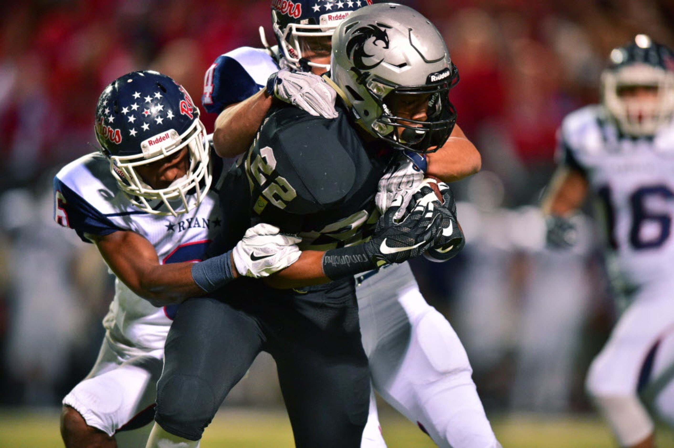 Guyer freshman running back Noah Cain (22) is brought down by Ryan sophomore defensive back...