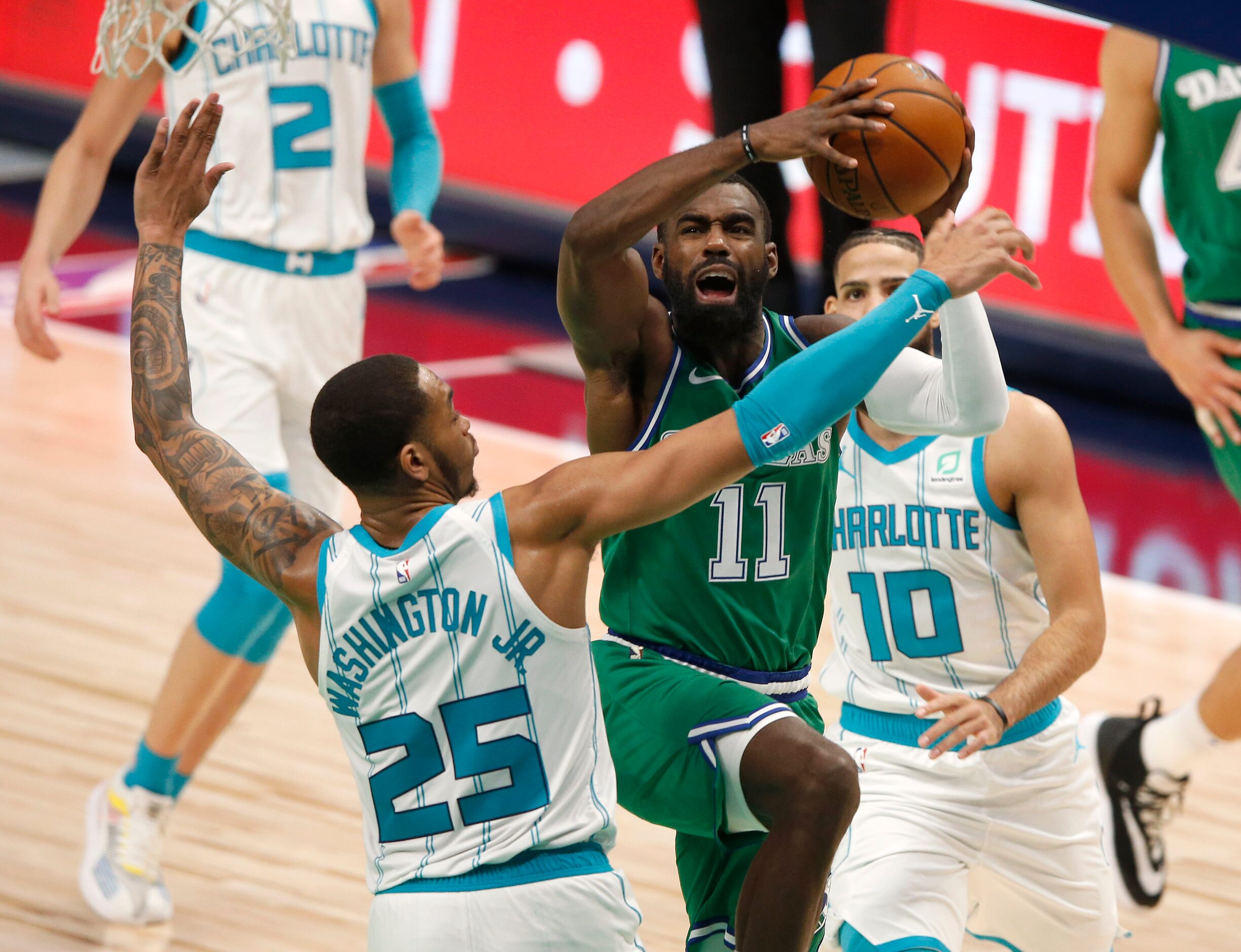 Dallas Mavericks guard Tim Hardaway Jr. (11) attempts a shot as he is defended by Charlotte...