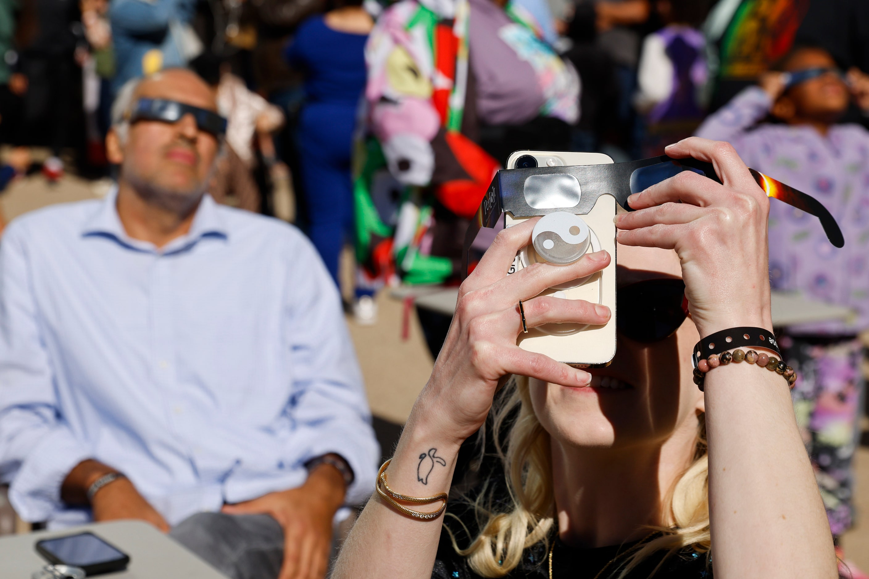 Kittie Greer of Dallas takes a photo of the annular solar eclipse on Saturday, Oct. 14,...