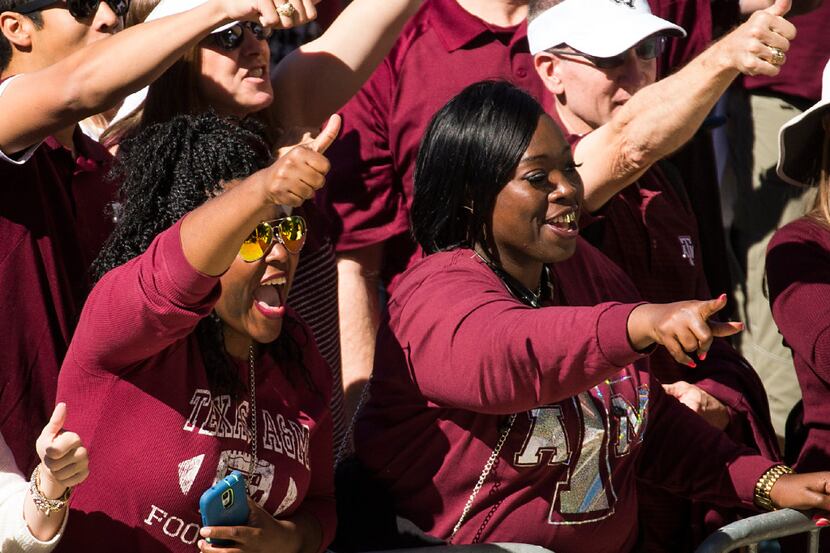 Texas A&M fans cheer as the team buses arrive before an NCAA college football game against...