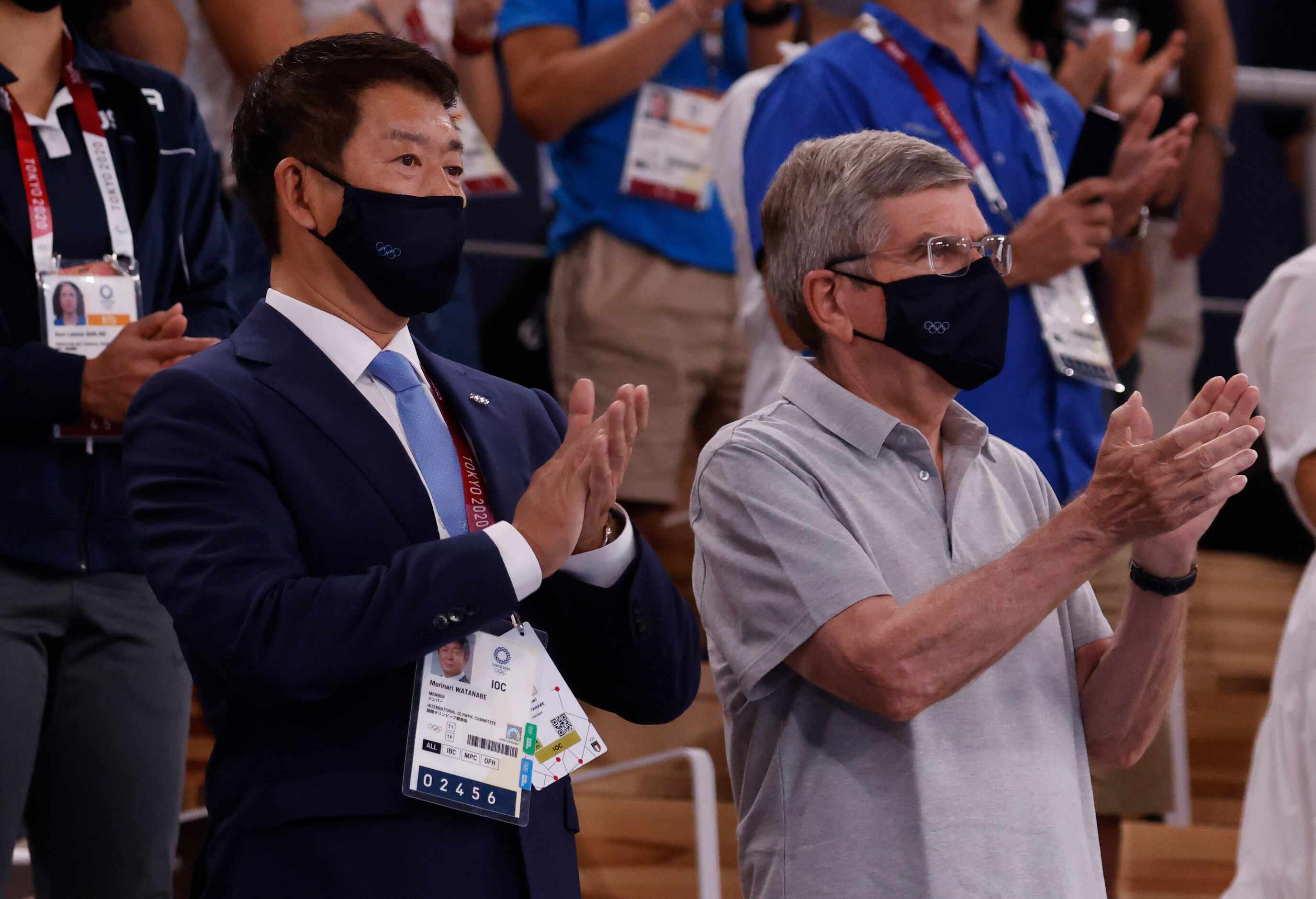 Morinari Watanabe and IOC president Thomas Bach clap as the gymnast for the balance beam are...