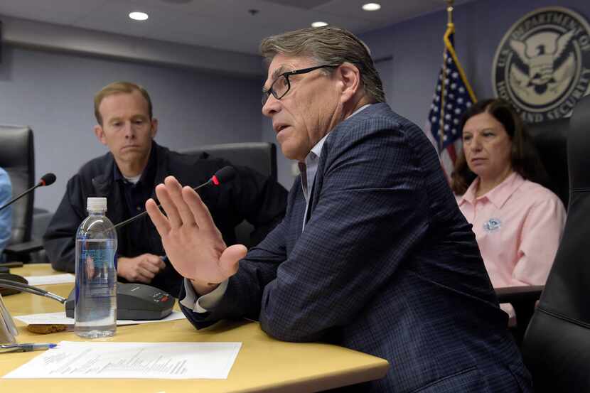 Energy Secretary Rick Perry, center, flanked by Federal Emergency Management Agency...