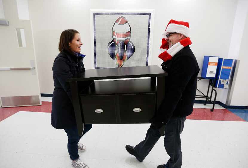 Hayley Heider (left) and Dave Rogers of Looney and Associates carry in a table for a nearly...