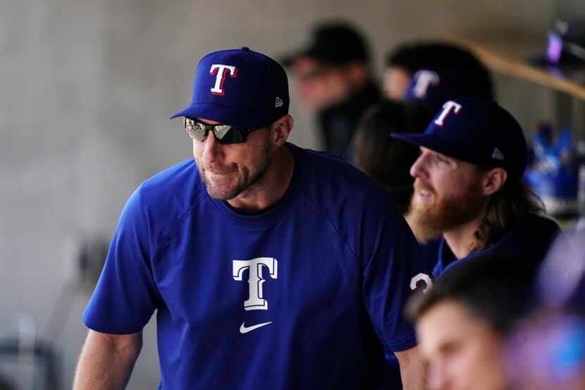 Texas Rangers pitcher Max Scherzer watches from the dugout during the seventh inning of a...