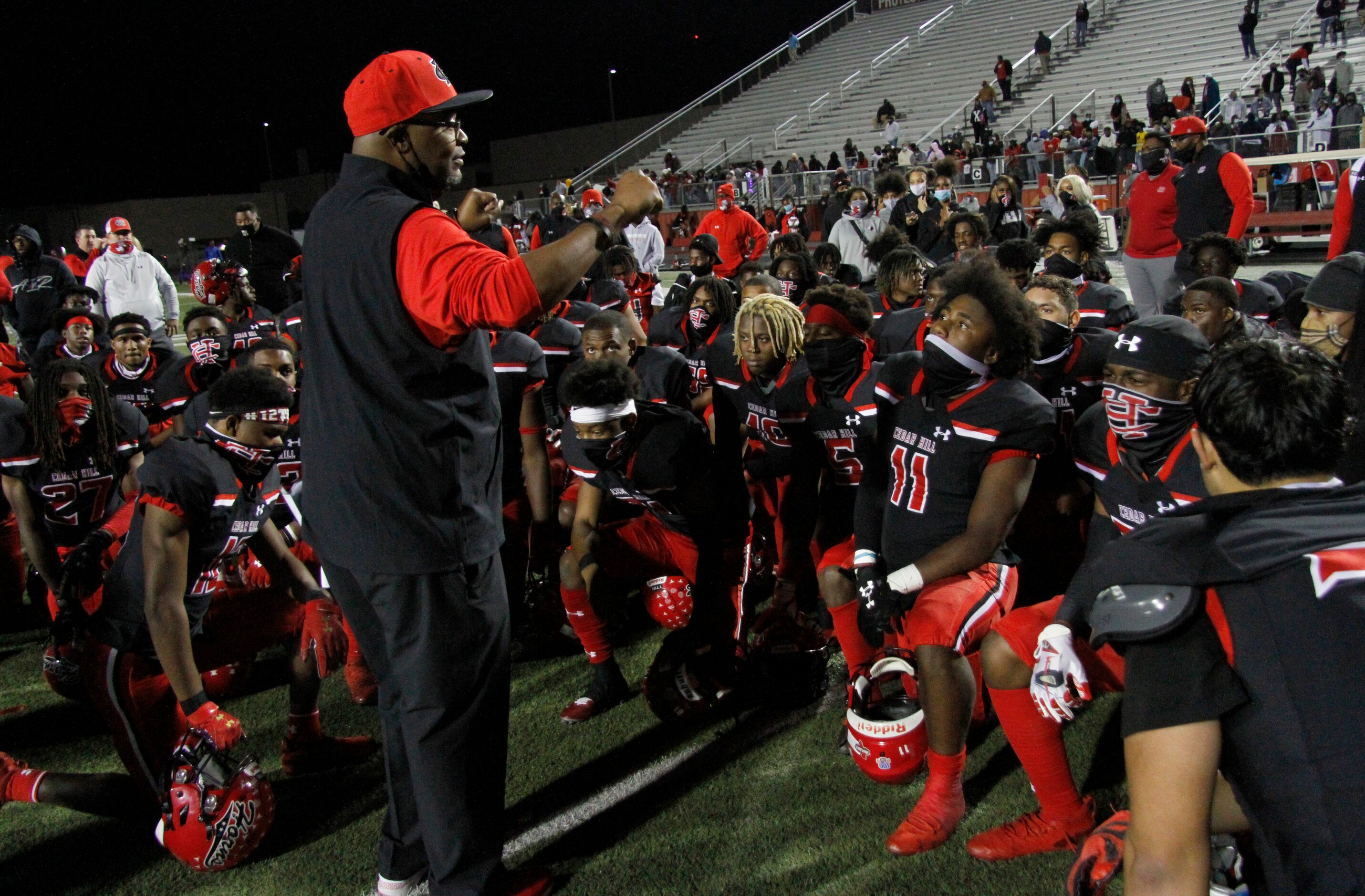 Cedar Hill head coach Carlos Lynn shares words of encouragement with his players following...